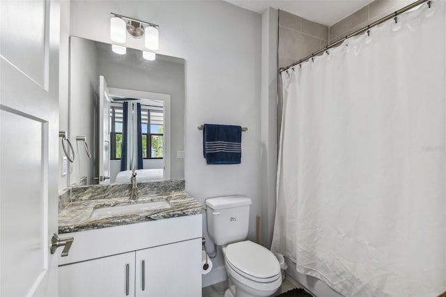 bathroom with curtained shower, vanity, and toilet