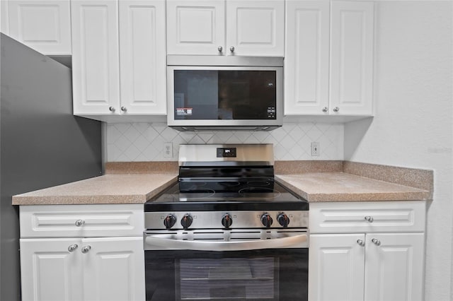 kitchen featuring white cabinetry, appliances with stainless steel finishes, and tasteful backsplash