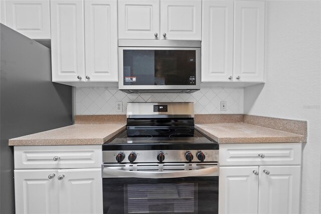 18001 Richmond Place Dr Unit 511, Tampa, FL 33647 - kitchen with appliances with stainless steel finishes, backsplash, white cabinets, and light countertops