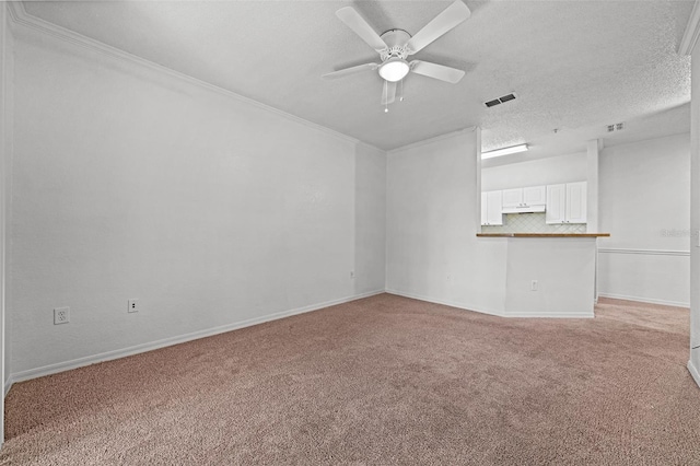 unfurnished living room featuring light colored carpet, ornamental molding, and a textured ceiling