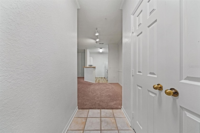 corridor featuring light carpet and a textured ceiling