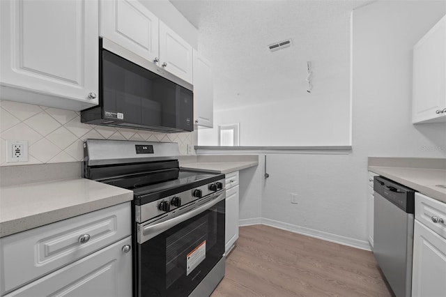 kitchen with backsplash, a textured ceiling, stainless steel appliances, light hardwood / wood-style flooring, and white cabinetry