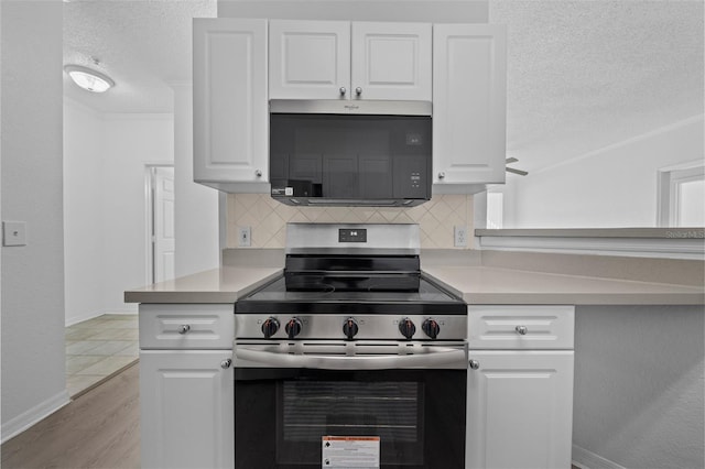 kitchen with decorative backsplash, appliances with stainless steel finishes, ornamental molding, light hardwood / wood-style flooring, and white cabinetry