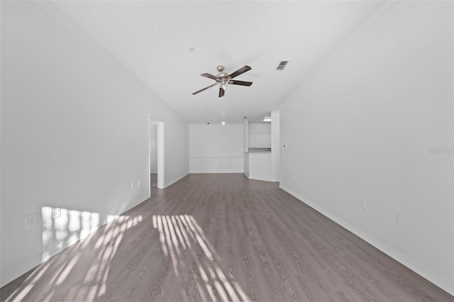 unfurnished living room featuring ceiling fan, wood-type flooring, and crown molding