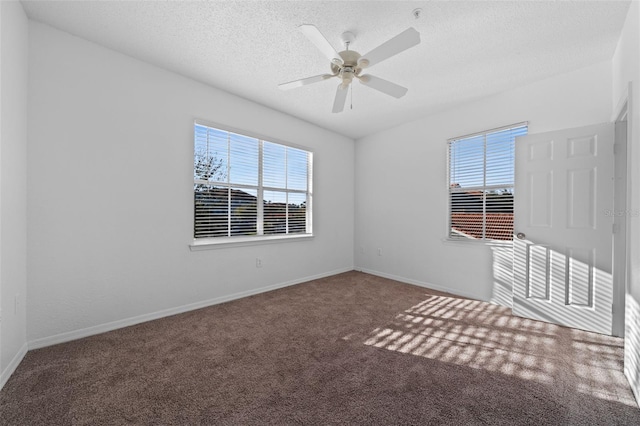 carpeted empty room featuring ceiling fan and a textured ceiling