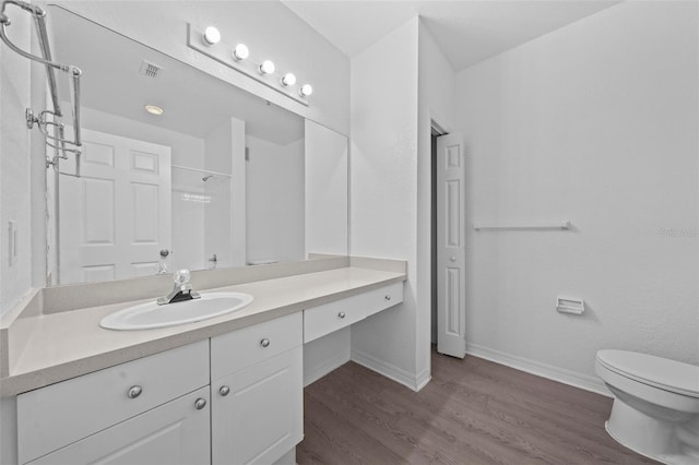 bathroom with vanity, toilet, wood-type flooring, and walk in shower