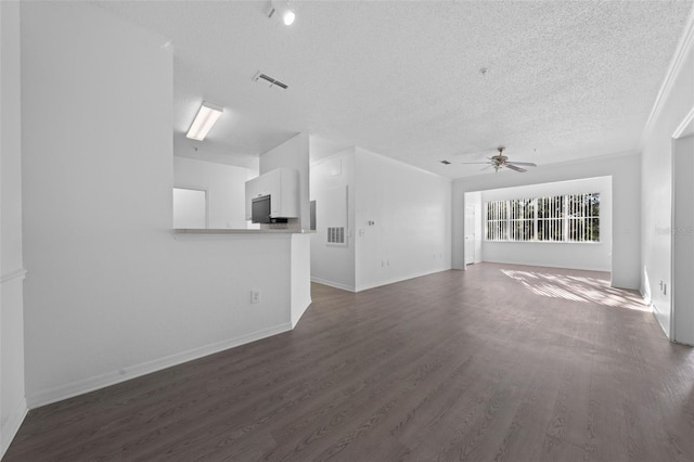 unfurnished living room featuring ceiling fan, dark wood-type flooring, and a textured ceiling