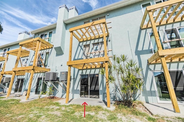 rear view of property featuring a patio, central AC, and a balcony