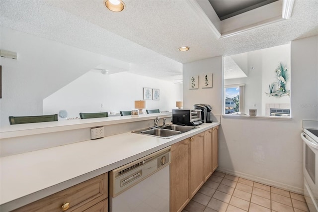 kitchen with white appliances, light brown cabinetry, sink, a textured ceiling, and light tile patterned floors