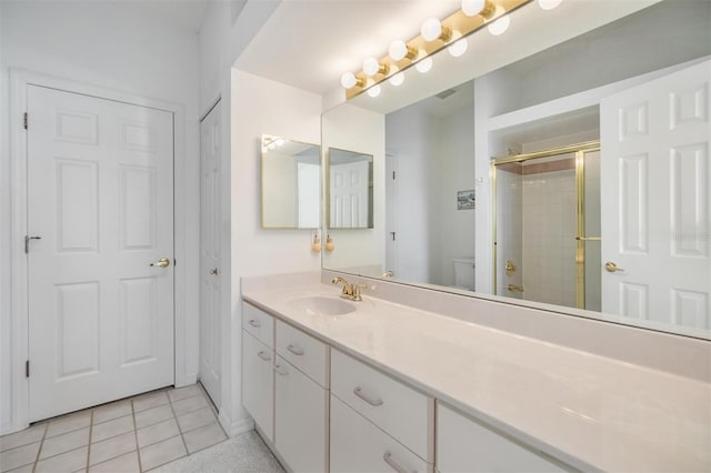 bathroom featuring toilet, an enclosed shower, vanity, and tile patterned floors