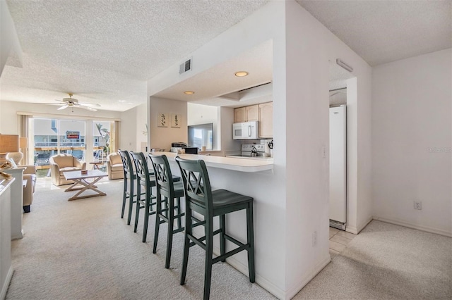 kitchen with light carpet, white appliances, visible vents, and light countertops