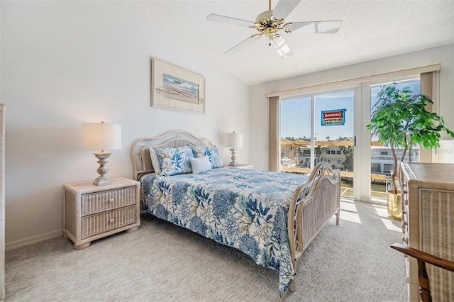 bedroom featuring light carpet, a textured ceiling, lofted ceiling, and access to exterior