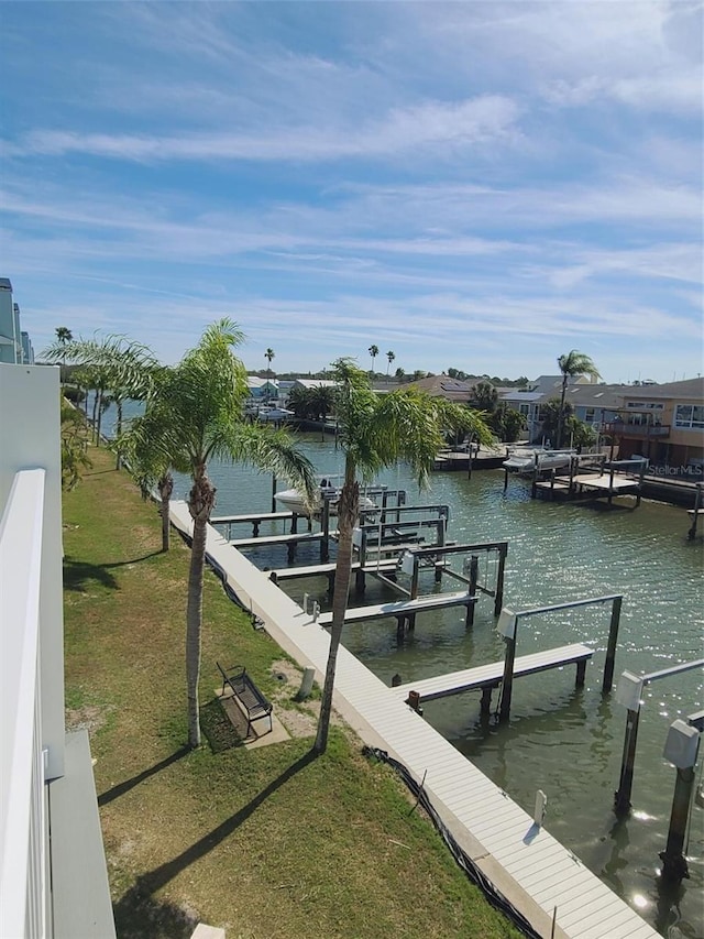 dock area featuring a water view, a lawn, and boat lift