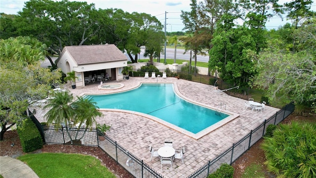 view of swimming pool with a hot tub and a patio area