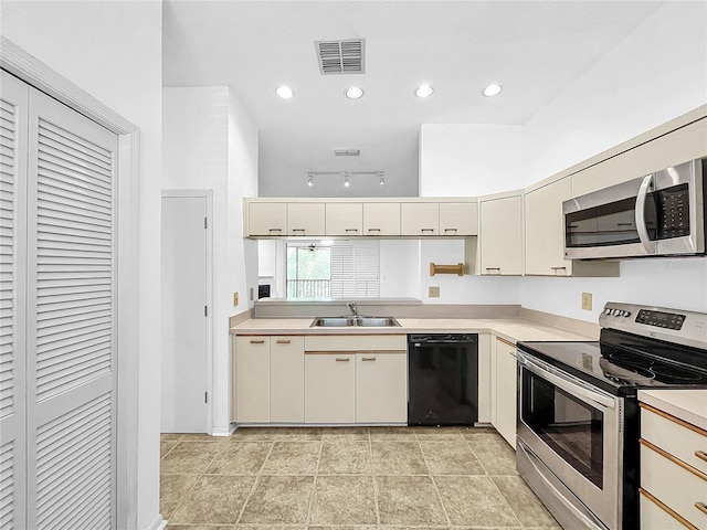 kitchen with cream cabinets, stainless steel appliances, and sink