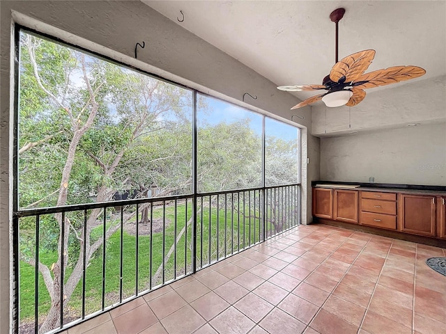 unfurnished sunroom featuring ceiling fan