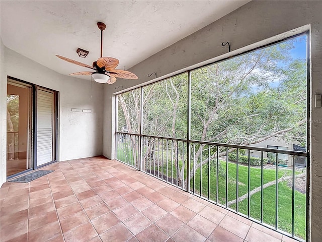 unfurnished sunroom featuring ceiling fan