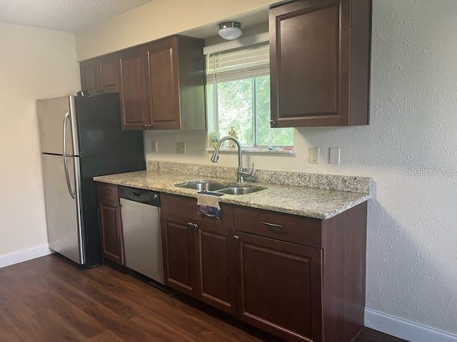 kitchen featuring a textured ceiling, sink, stainless steel appliances, dark brown cabinetry, and dark hardwood / wood-style flooring