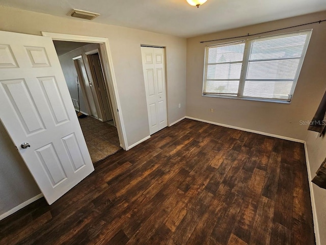 unfurnished bedroom with dark hardwood / wood-style floors