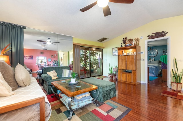 living room with a textured ceiling, lofted ceiling, ceiling fan, and dark wood-type flooring