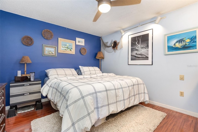 bedroom featuring ceiling fan, a textured ceiling, and dark hardwood / wood-style flooring