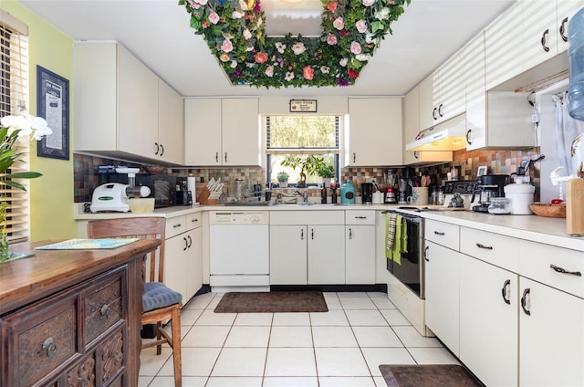 kitchen with light tile patterned floors, tasteful backsplash, white appliances, and white cabinetry