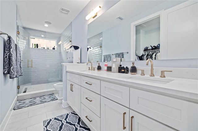 bathroom with vanity, toilet, tile patterned floors, and walk in shower