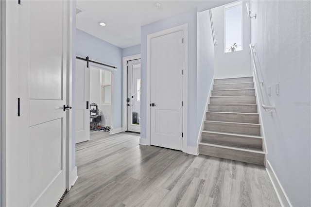 stairway with hardwood / wood-style flooring and a barn door