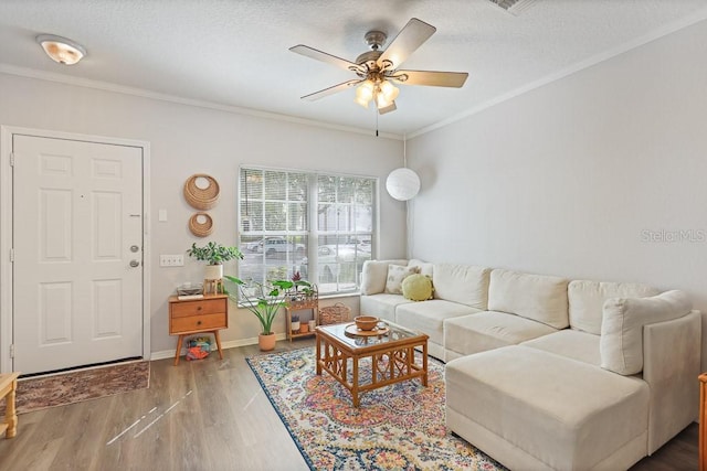 living room with wood-type flooring, ceiling fan, a textured ceiling, and crown molding