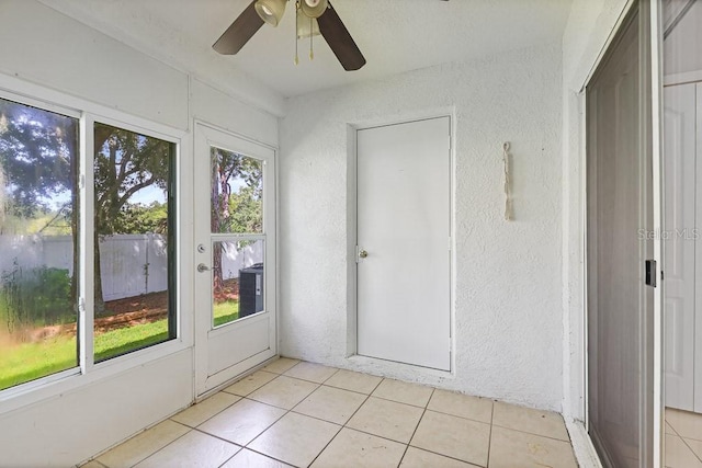 unfurnished sunroom featuring ceiling fan and a healthy amount of sunlight