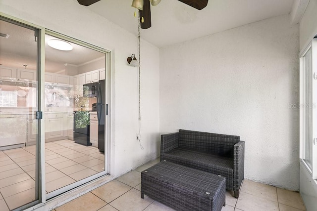 interior space with ceiling fan, ornamental molding, light tile patterned floors, and a wealth of natural light