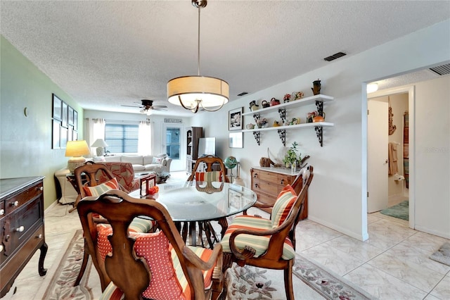 dining space featuring ceiling fan and a textured ceiling