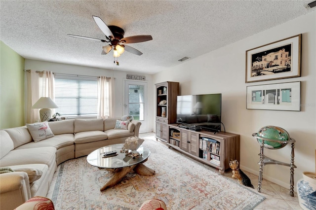 tiled living room with ceiling fan and a textured ceiling