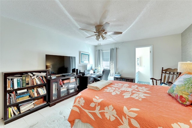 bedroom featuring a textured ceiling, light tile patterned floors, and ceiling fan