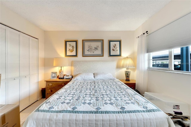 bedroom featuring a textured ceiling, a closet, and light tile patterned floors