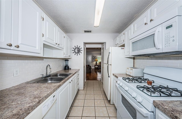 kitchen with sink, light tile patterned floors, white cabinetry, white appliances, and tasteful backsplash