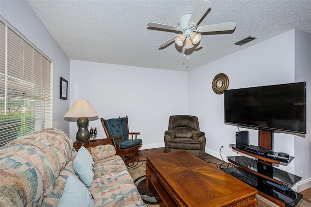 living room featuring hardwood / wood-style floors, a textured ceiling, and ceiling fan