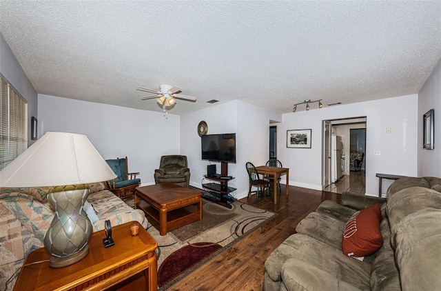 living room with a textured ceiling, dark hardwood / wood-style floors, and ceiling fan