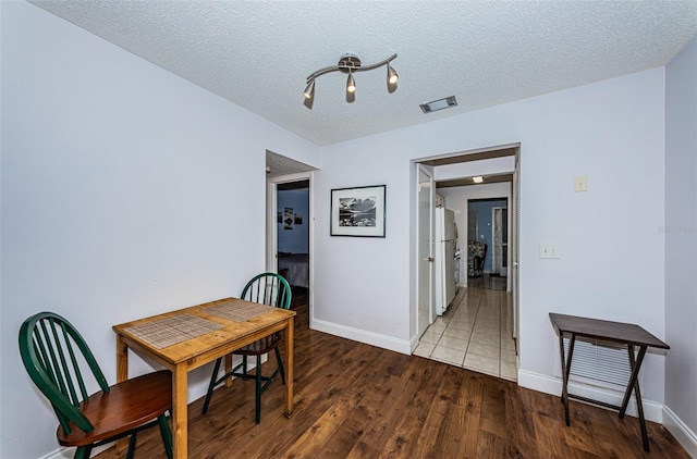 dining area with hardwood / wood-style floors and a textured ceiling