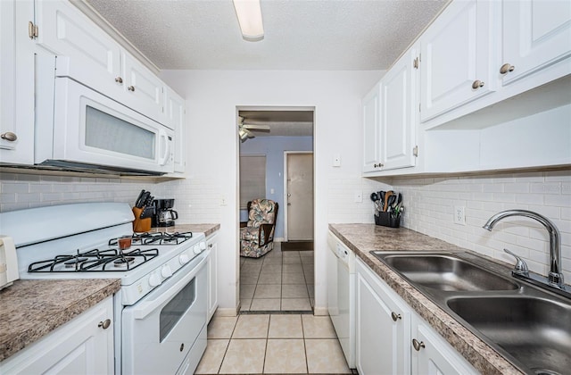 kitchen featuring sink, white cabinets, a textured ceiling, and white appliances