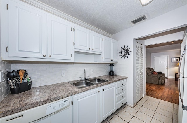 kitchen with white cabinetry, a textured ceiling, dishwasher, light hardwood / wood-style floors, and sink