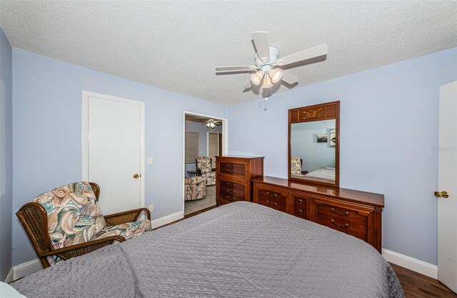 bedroom with ceiling fan, a textured ceiling, and hardwood / wood-style floors