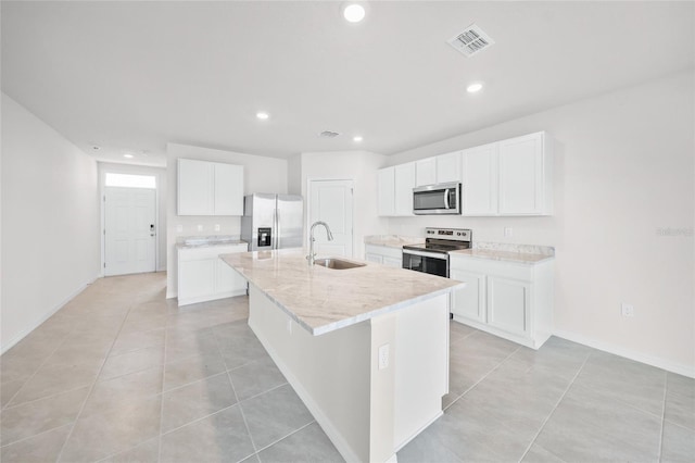 kitchen featuring white cabinets, stainless steel appliances, a center island with sink, and sink