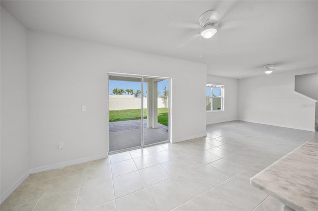 tiled empty room featuring ceiling fan