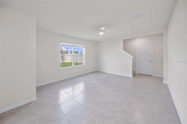 empty room with ceiling fan and light tile patterned floors