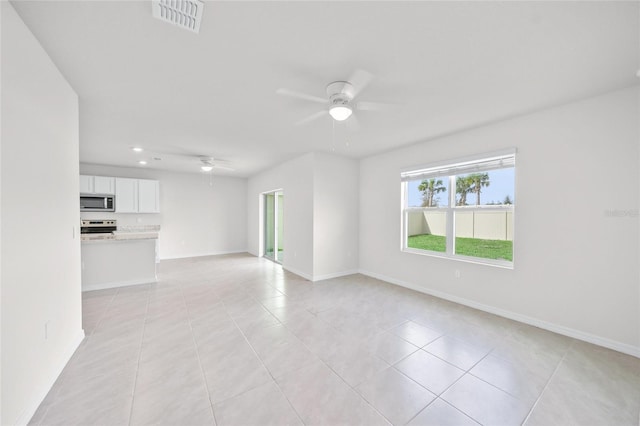 tiled spare room featuring ceiling fan