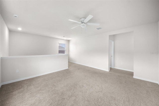 carpeted spare room featuring ceiling fan