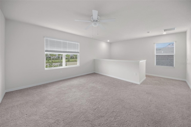 carpeted spare room with ceiling fan