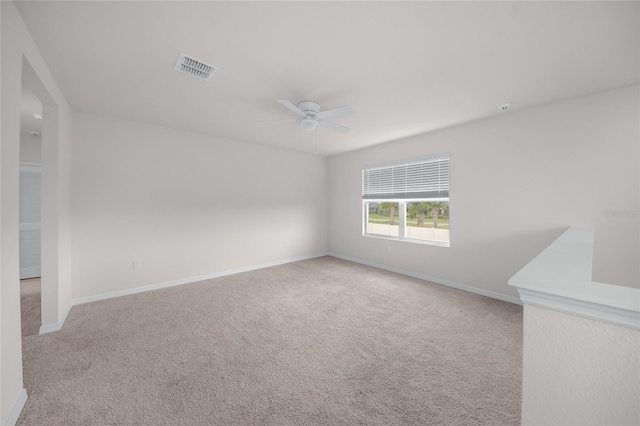 spare room featuring light carpet and ceiling fan