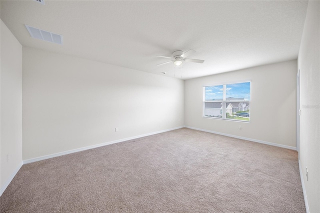 carpeted spare room with ceiling fan